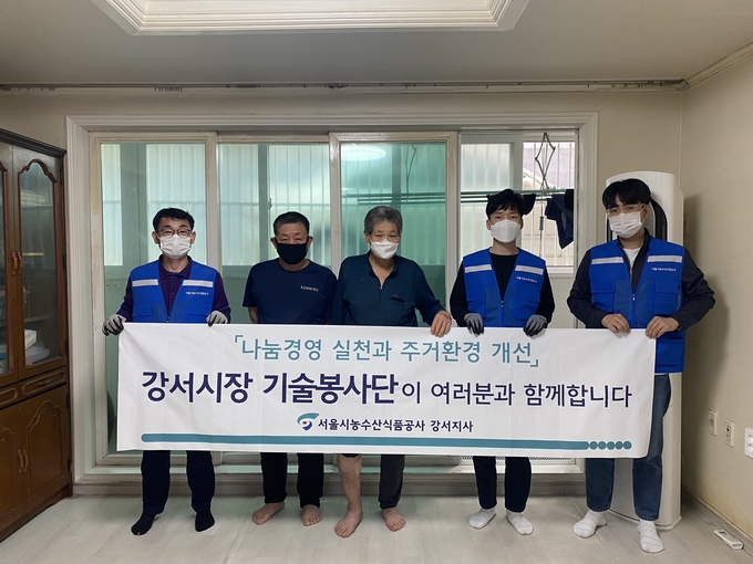 서울식품공사 강서지사 기술봉사단이 소외계측을 대상으로 한 집수리 봉사 후 기념촬영하고 있다.