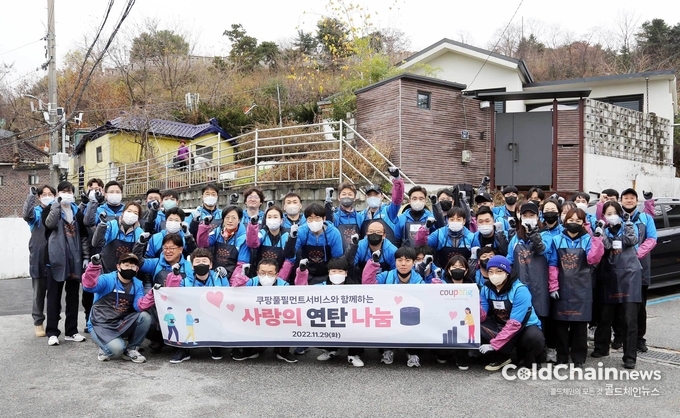 연탄 나눔 봉사활동에 참여한 참여자들이 기념사진을 찍고 있다.